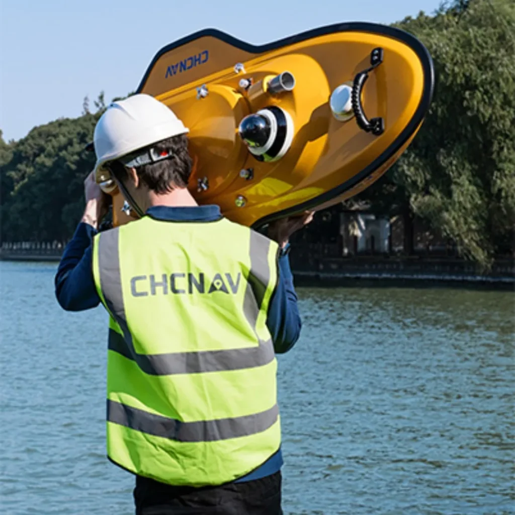 Operador desplegando el USV CHCNAV Apache 6 en un río